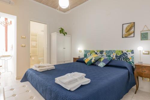 Un dormitorio con una cama azul con toallas. en B&B King, en Verona