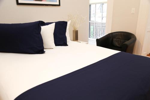 Un dormitorio con una cama con almohadas azules y una silla en Comfy Beacon Hill Studio Great for Work Travel #7, en Boston