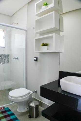 a bathroom with a toilet and a sink at Casa Tô D`Boa Capitólio in Capitólio