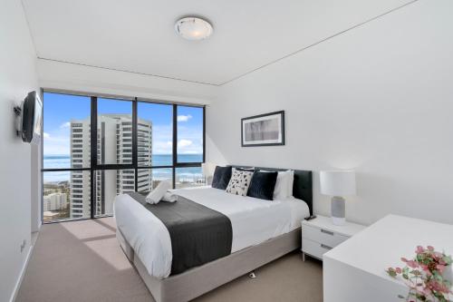 a bedroom with a large bed and a large window at Sierra Grand Broadbeach - GCLR in Gold Coast