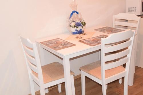 シビウにあるSerb Rafilaの白いテーブル(椅子2脚付)、白いテーブル、椅子