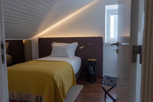 a bedroom with a bed with a yellow blanket at O Paço - exclusive accommodation in Tomar