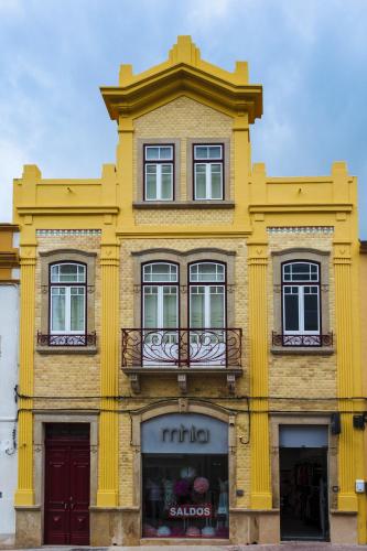 a yellow building with a balcony on top of it at O Paço - exclusive accommodation in Tomar