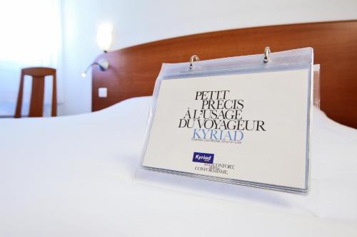 a sign on the side of a bed at Kyriad Orthez in Orthez