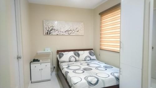 een kleine slaapkamer met een bed en een raam bij YulZ 516 at Cityscape in Bacolod