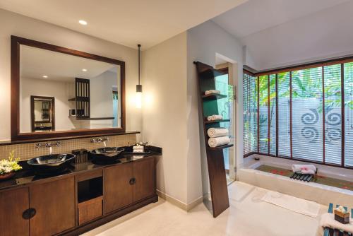 a bathroom with two sinks and a large mirror at Mövenpick Asara Resort & Spa Hua Hin in Hua Hin
