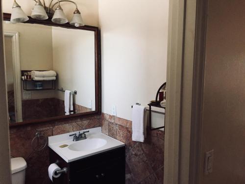 een badkamer met een wastafel en een spiegel bij The Shores Inn in Ventura