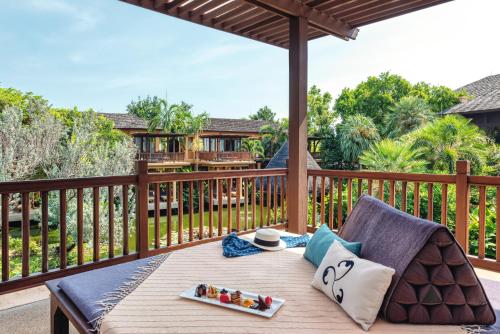 a table on the deck of a house at Mövenpick Asara Resort & Spa Hua Hin in Hua Hin