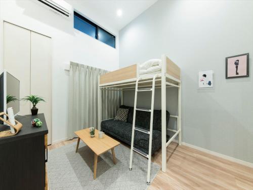 a small room with a bunk bed and a desk at TRIP POD SUMIYOSHI C in Fukuoka
