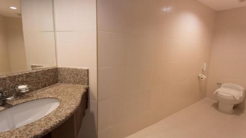 La salle de bains est pourvue d'un lavabo et de toilettes. dans l'établissement Canyon Cove Hotel and Spa, à Nasugbu