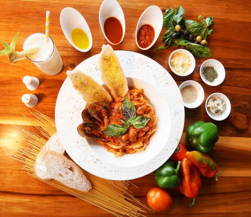 a plate of spaghetti with bread on a wooden table at Cuna Hotel in El Nido