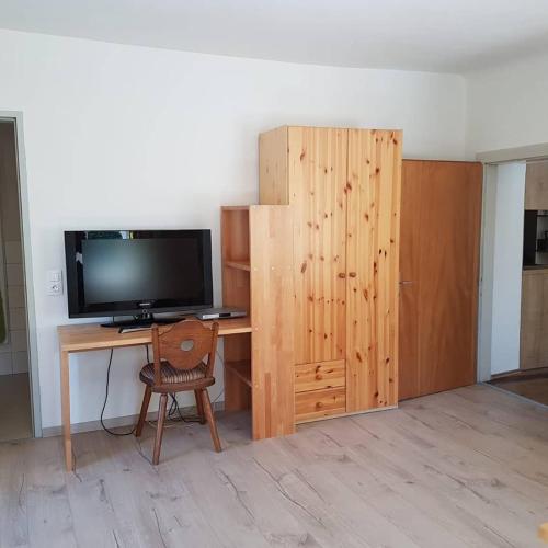 a room with a desk with a television and a wooden cabinet at Amtmannhaus Ferienunterkunft in Irdning