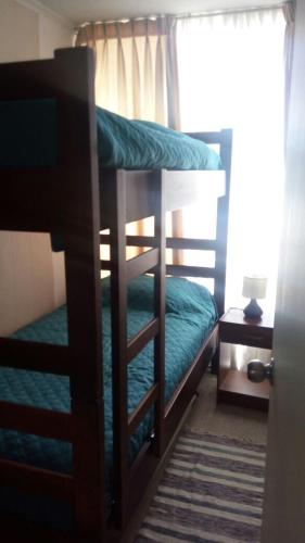 a bedroom with two bunk beds and a window at Departamentos Rohe in Puerto Montt