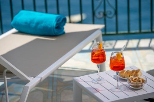 two cocktails on a white table with snacks at Hotel Villa Maria Pia in Praiano