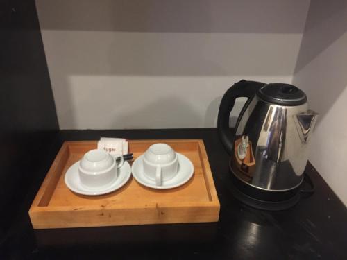 a tea kettle and two cups on a wooden tray at Private Boutique Home with Pool, The Fin Angkor Boutique in Siem Reap