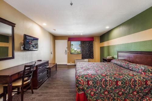 Habitación de hotel con cama y escritorio en Budget Inn Anaheim / Santa Fe Springs, en Norwalk