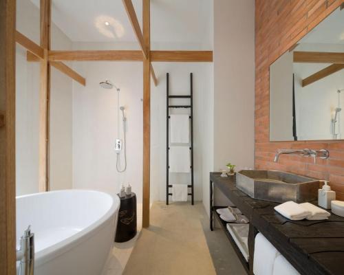 a bathroom with a bath tub and a sink at Sala Ayutthaya in Phra Nakhon Si Ayutthaya