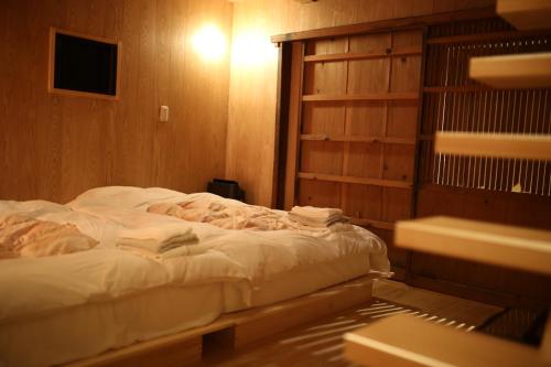 a bedroom with a bed in a wooden room at 無鹿リゾート in Kokuryō