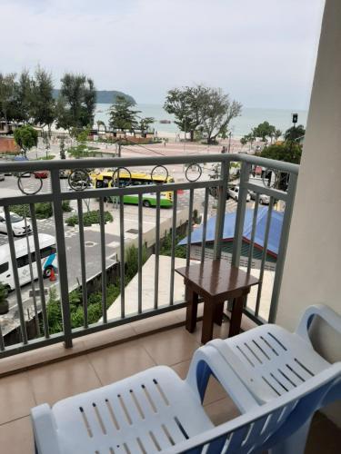 a balcony with chairs and a table and a view of a street at Paretto Seaview Hotel in Pantai Cenang