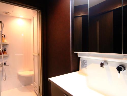 a bathroom with a sink and a shower and a toilet at Amagiso in Kawazu