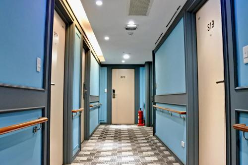 a hallway with blue walls and a red fire hydrant at Hotel Champs Elysées in Taichung