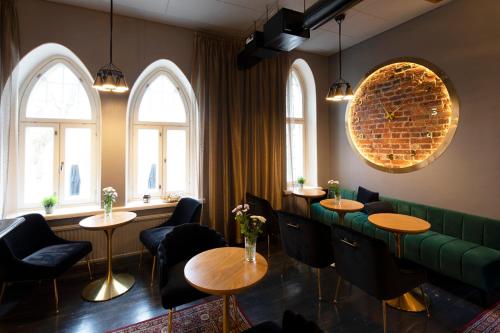 a restaurant with tables and chairs and windows at Opiston Kunkku in Lahti