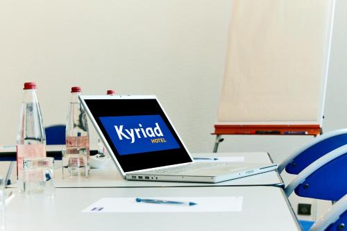 a laptop computer sitting on top of a table at Hôtel Restaurant Kyriad Mulhouse Nord Illzach in Illzach