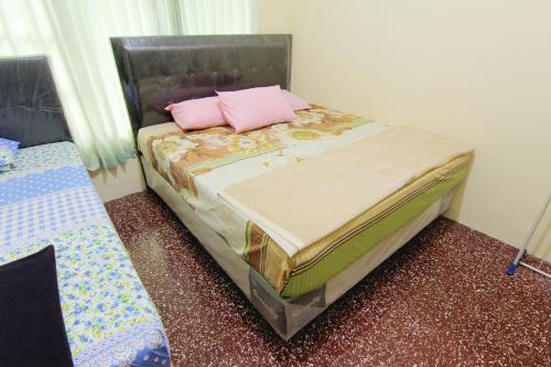 a bed with two pink pillows on top of it at Hotel Wijaya 1 Kaliurang in Yogyakarta