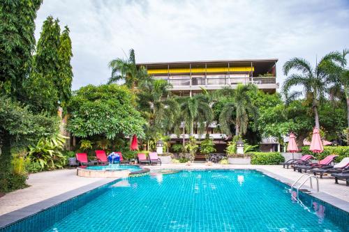 a swimming pool with chairs and a building at Asleep by Lantana in North Pattaya