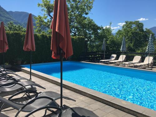 basen z krzesłami i parasolami w obiekcie Residence Bichler w Meranie