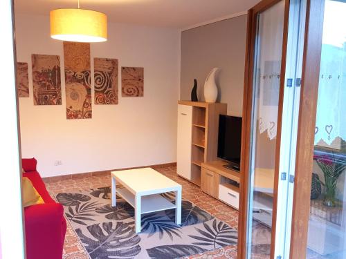 ein Wohnzimmer mit einem roten Sofa und einem Tisch in der Unterkunft Appartamento la Canvetta in Santa Maria Maggiore
