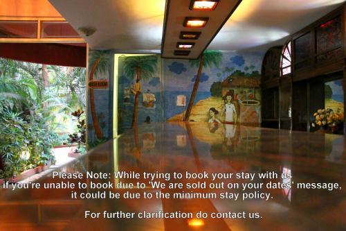 a mural on the wall of a building with palm trees at Palm Grove Cottages - Leisure Resort in Benaulim