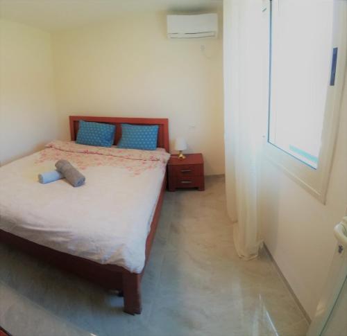 a small bedroom with a bed and a window at Charming beach 2 room flat in Haifa