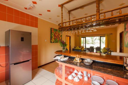 a kitchen with orange tile walls and a counter at Casa De Leela Self Catering Guest House in La Digue