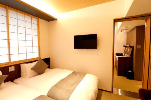 a hotel room with a bed and a mirror at Stay SAKURA Kyoto SUZAKU OJI in Kyoto