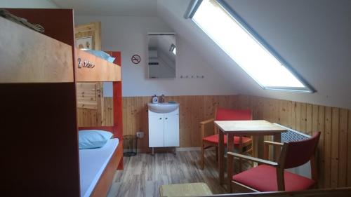 Zimmer mit einem Bett, einem Tisch und einem Fenster in der Unterkunft World's End Hostel in Myza Igaste