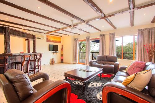 a living room with leather chairs and a table at Royal Marlothi Kruger Safari Lodge and Spa in Marloth Park