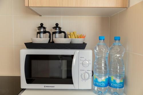two bottles of water sitting on top of a microwave at Oceania Bay Village in Pyla