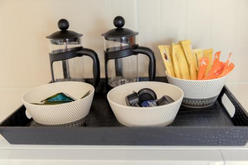 a shelf with three bowls and a coffee maker at Oceania Bay Village in Pyla