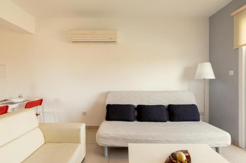 a white room with a bed and a couch at Oceania Bay Village in Pyla