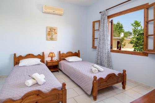 1 dormitorio con 2 camas y ventana en Voula Apartments en Gaios