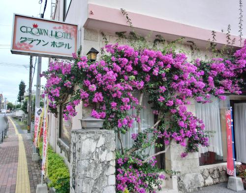 a building with purple flowers on the side of it at Crown Hotel Okinawa in Okinawa City