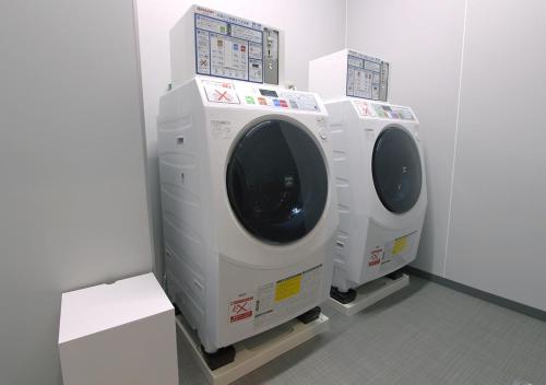 two washing machines are lined up in a room at Arigato Stay Kanazawa Katamachi in Kanazawa