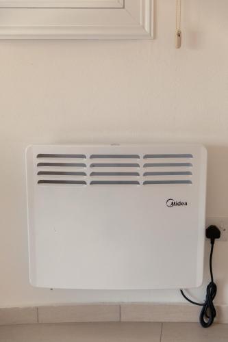 a white air conditioner in a white wall at Oceania Bay Village in Pyla