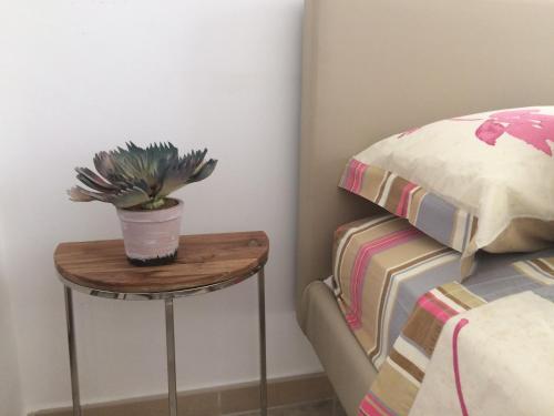 a table with a potted plant on it next to a bed at casa gramazio in Manfredonia