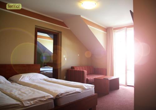 a hotel room with two beds and a chair at Penzion Termal in Bojnice