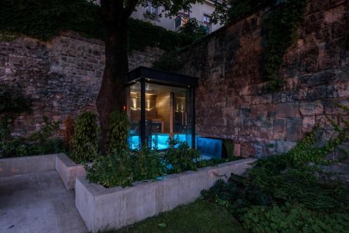 a glass house with a pool in a brick wall at Castle Apartments Budapest in Budapest