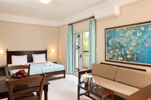 Talos Hotel Apartments في كاتو داراتسو: غرفة نوم مع سرير وغرفة معيشة مع أريكة