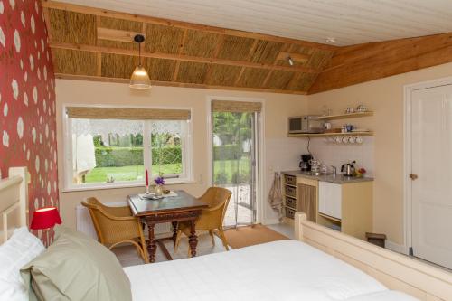 a bedroom with a bed and a table and a kitchen at Bed And Breakfast Rodenberg in Driebergen