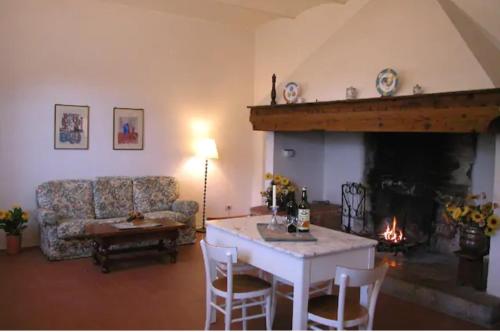 a living room with a table and a fireplace at Agriturismo La Moraia in Poggibonsi